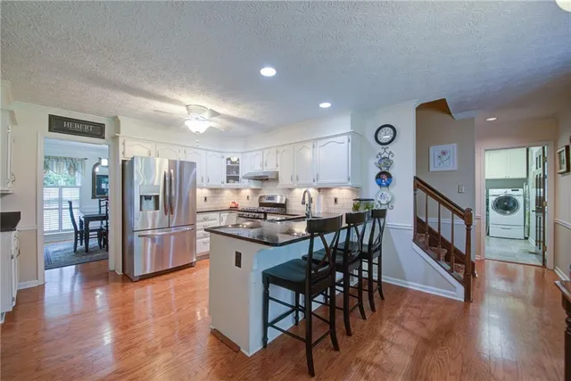 a kitchen with stainless steel appliances granite countertop a refrigerator sink and stove