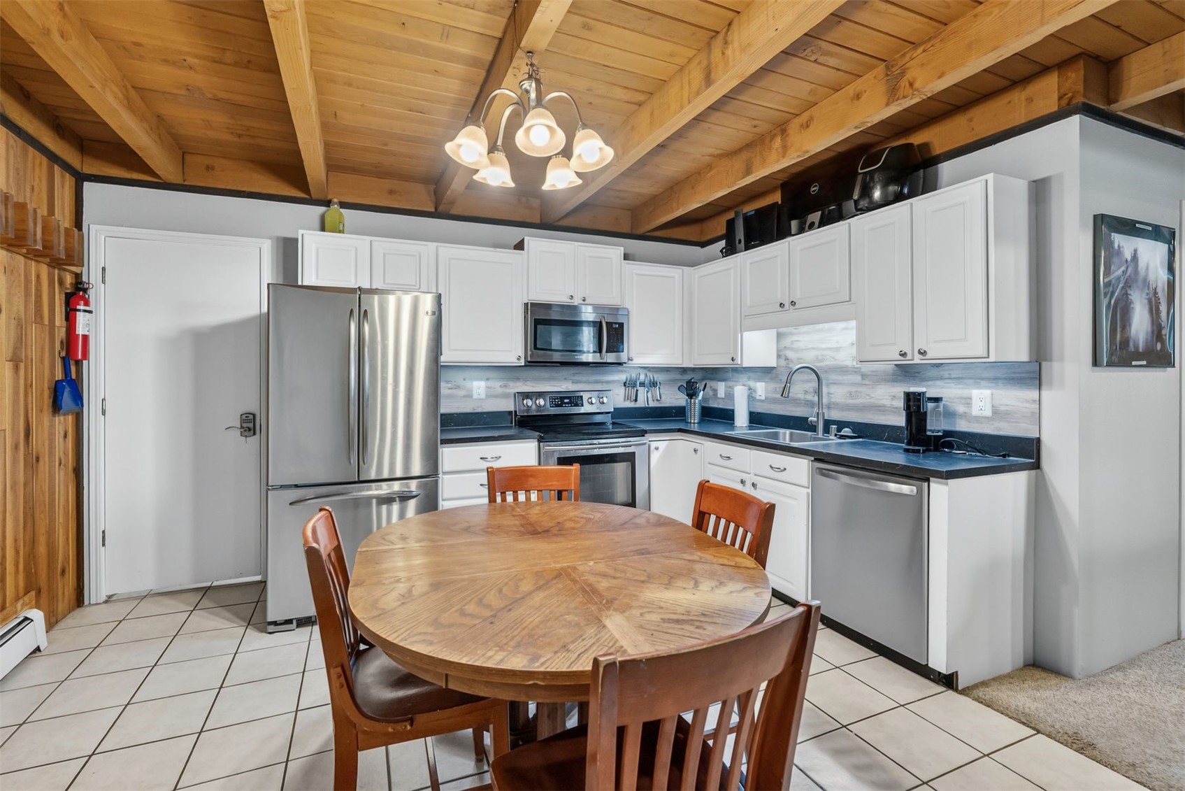 8100 Ryan Gulch Road, Unit 106 Wildernest, CO 80498 - Photo 6 of 43 a kitchen with stainless steel appliances granite countertop a refrigerator a stove top oven a sink dishwasher and white cabinets
