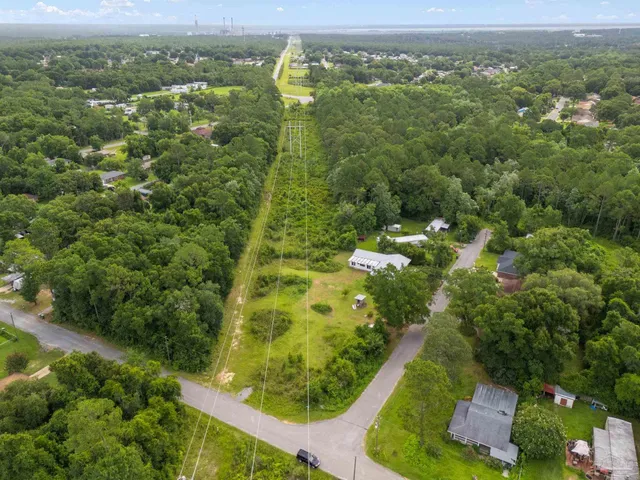 an aerial view of residential houses with outdoor space and trees