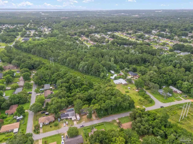 an aerial view of residential houses with outdoor space and trees