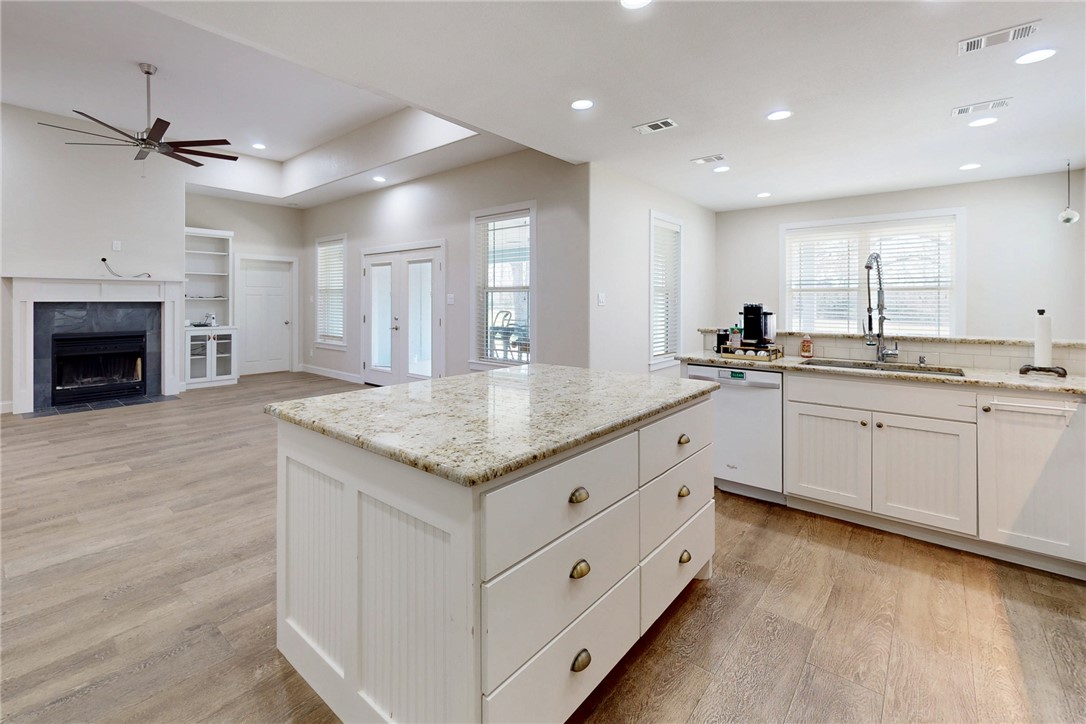 4168 Owensville Cemetery Road Franklin, TX 77856 - Photo 15 of 35 a kitchen with granite countertop a sink stainless steel appliances white cabinets and wooden floor
