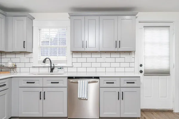 a kitchen with cabinets appliances a sink and a window