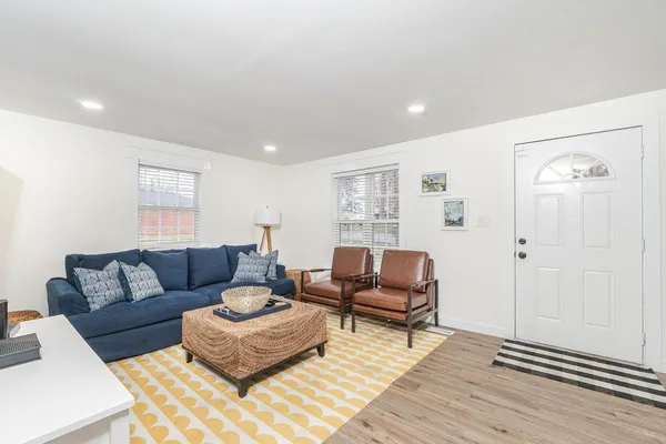 a living room with furniture and wooden floor