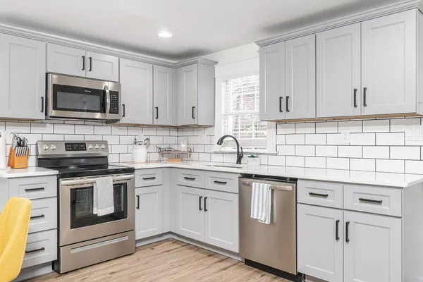 a kitchen with granite countertop a sink stainless steel appliances and window
