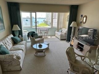 4575 Cove Circle, Unit 605 Madeira Beach, FL 33708 - Photo 1 of 1 a living room with furniture and a large window