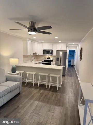 a kitchen with stainless steel appliances kitchen island granite countertop a table chairs microwave and cabinets