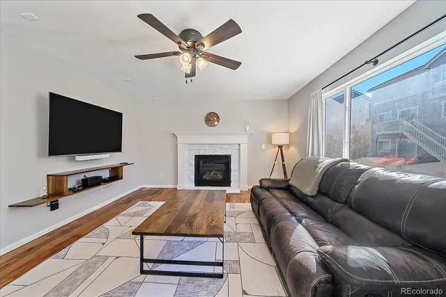 a living room with a couch a flat screen tv and a fireplace