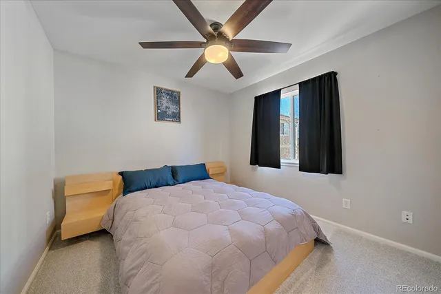 a bedroom with a bed and a ceiling fan