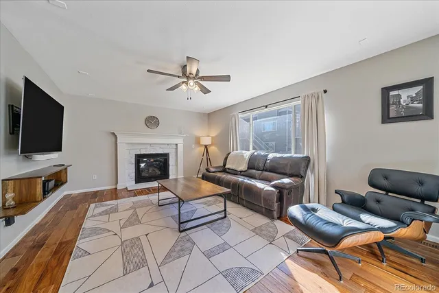 a living room with furniture a flat screen tv and a fireplace