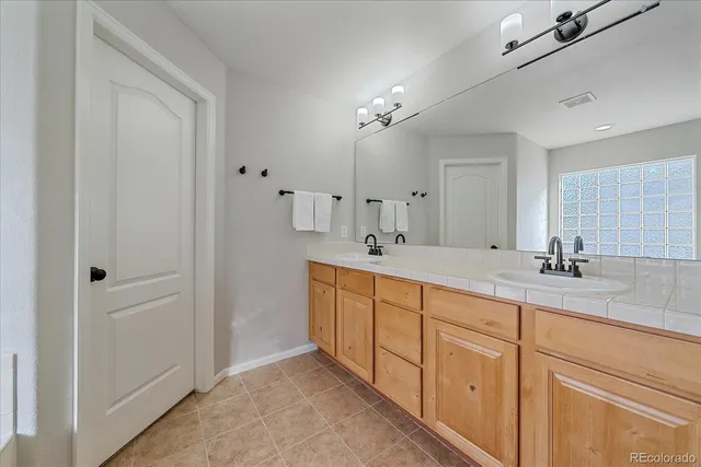 a spacious bathroom with double sink and a mirror