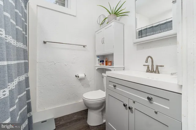 a bathroom with a sink a mirror a toilet and a shower