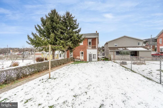 a front view of a building with cars parked on road