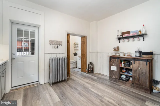 a view of a hallway with wooden floor and a cabinet