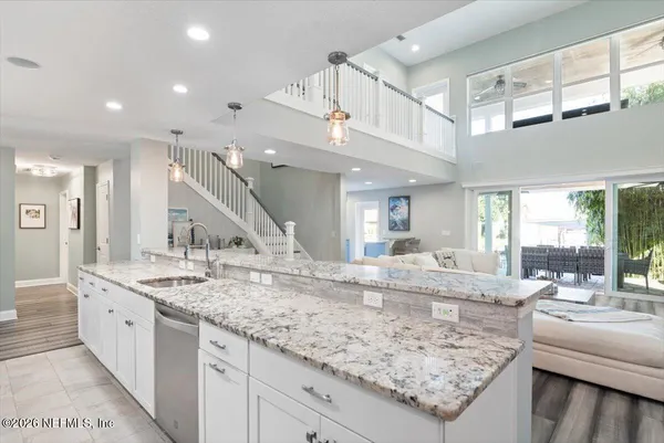 a kitchen with stainless steel appliances kitchen island granite countertop a stove refrigerator and cabinets