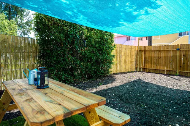 a view of a patio with table and chairs under an umbrella