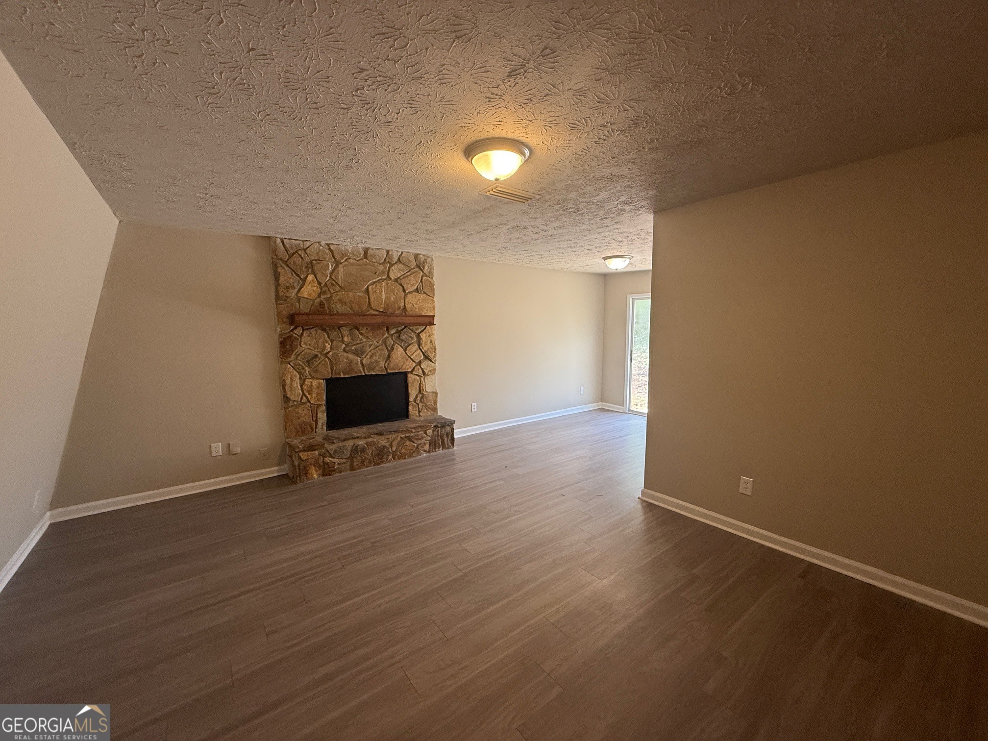 255 Rustwood Drive Athens, GA 30606 - Photo 1 of 9 an empty room with wooden floor and fireplace
