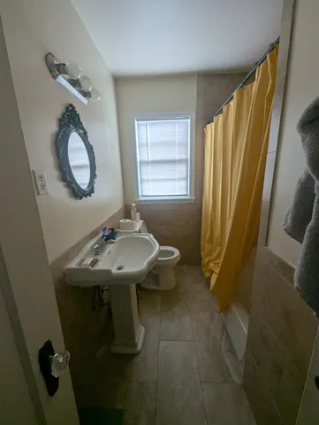 a bathroom with a sink a toilet and mirror