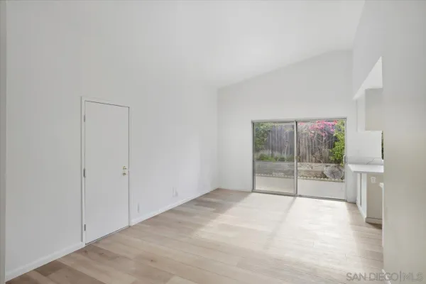 an empty room with sliding door and garden view