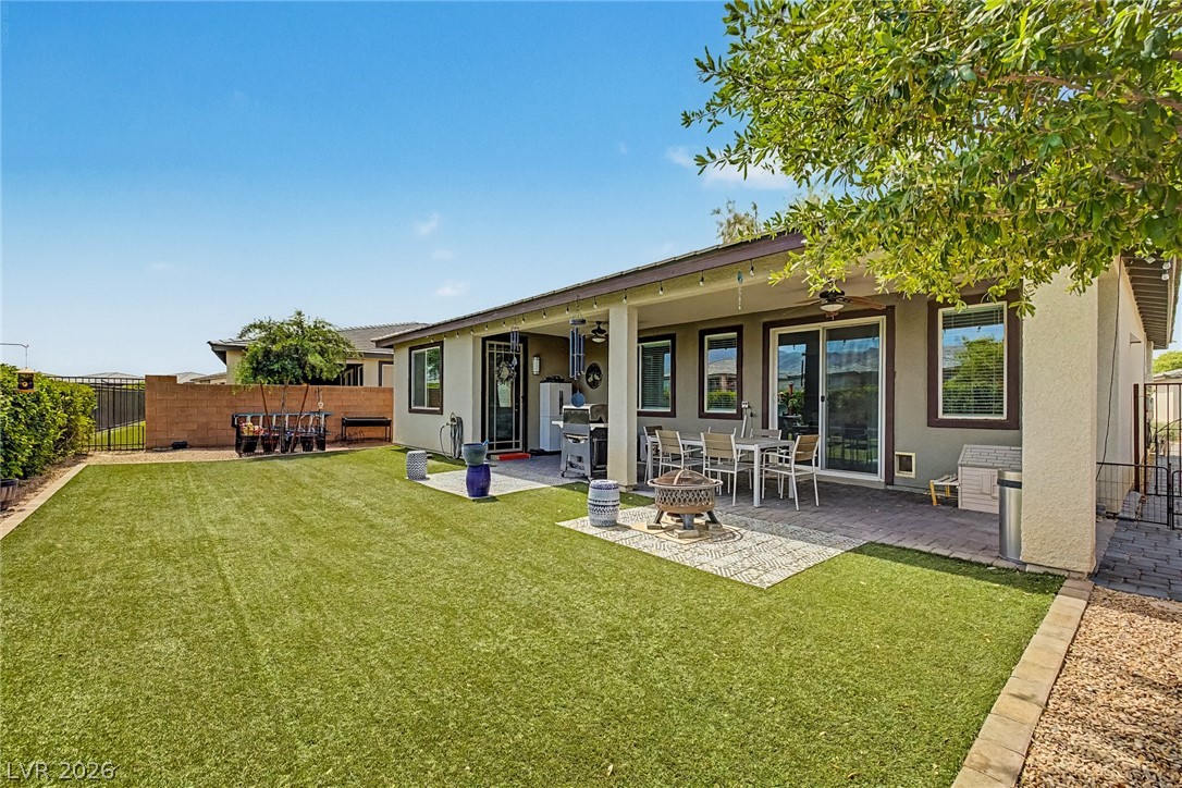 4914 East Beacon Ridge Drive Pahrump, NV 89061 - Photo 3 of 34 A spacious backyard awaits, featuring a covered patio ideal for outdoor entertaining and a manicured lawn.