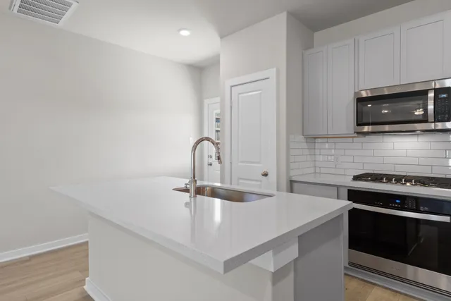 a kitchen with granite countertop a sink a stove and microwave