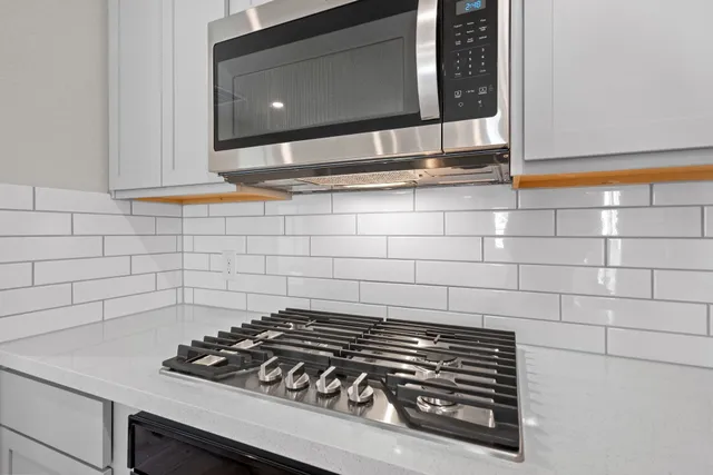 a stove top oven sitting inside of a kitchen