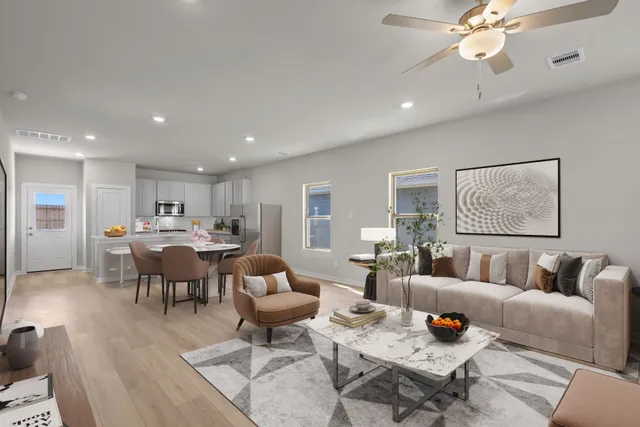a living room with lots of furniture and view of kitchen