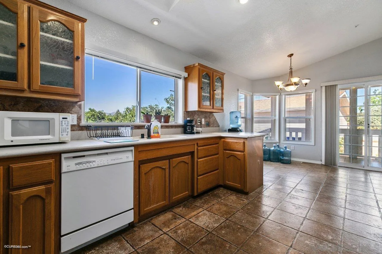 8622 Gardena Road Lakeside, CA 92040 - Photo 14 of 29 a kitchen with a sink window and cabinets