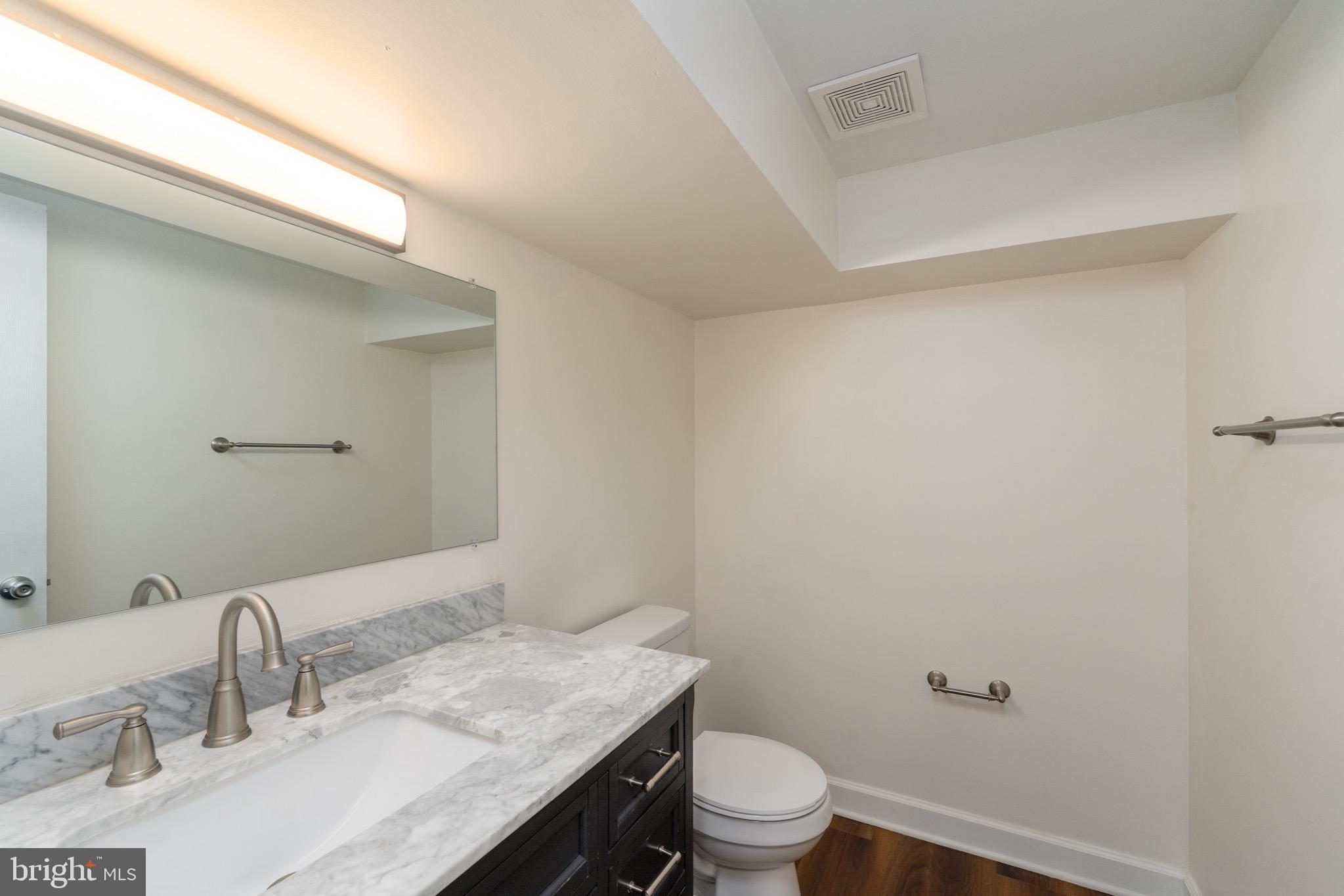 123 East Cross Street Baltimore, MD 21230 - Photo 31 of 33 a bathroom with a granite countertop sink a toilet and a mirror