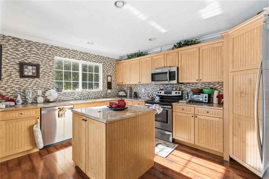 2640 Waymeyer Drive Orlando, FL 32812 - Photo 8 of 33 a kitchen with stainless steel appliances granite countertop a stove a sink and a microwave