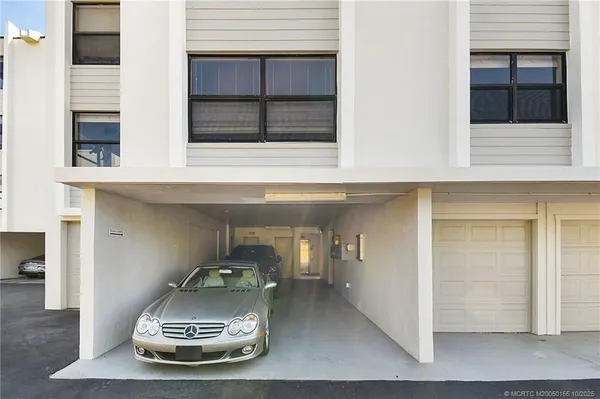 a view of a dining room with furniture a kitchen and chandelier