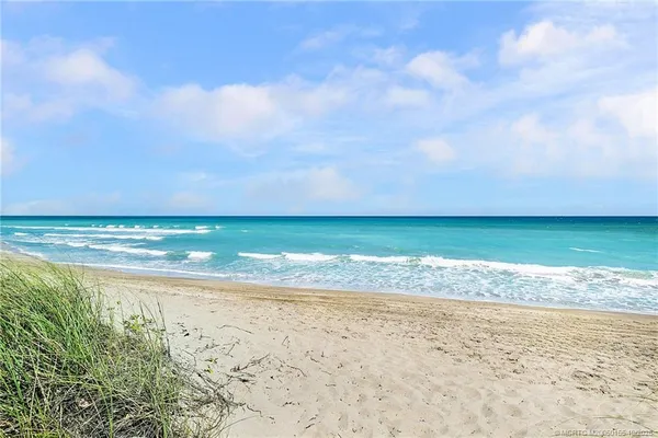 a bedroom with a large bed a flat tv screen and a dresser