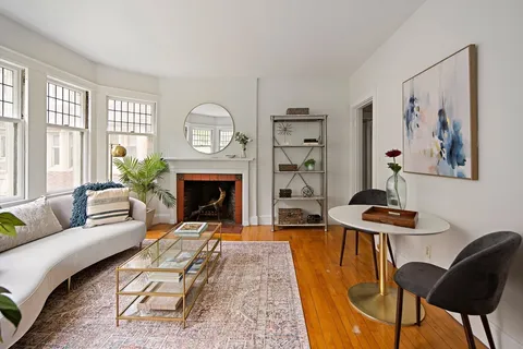 a living room with furniture a fireplace and a large window
