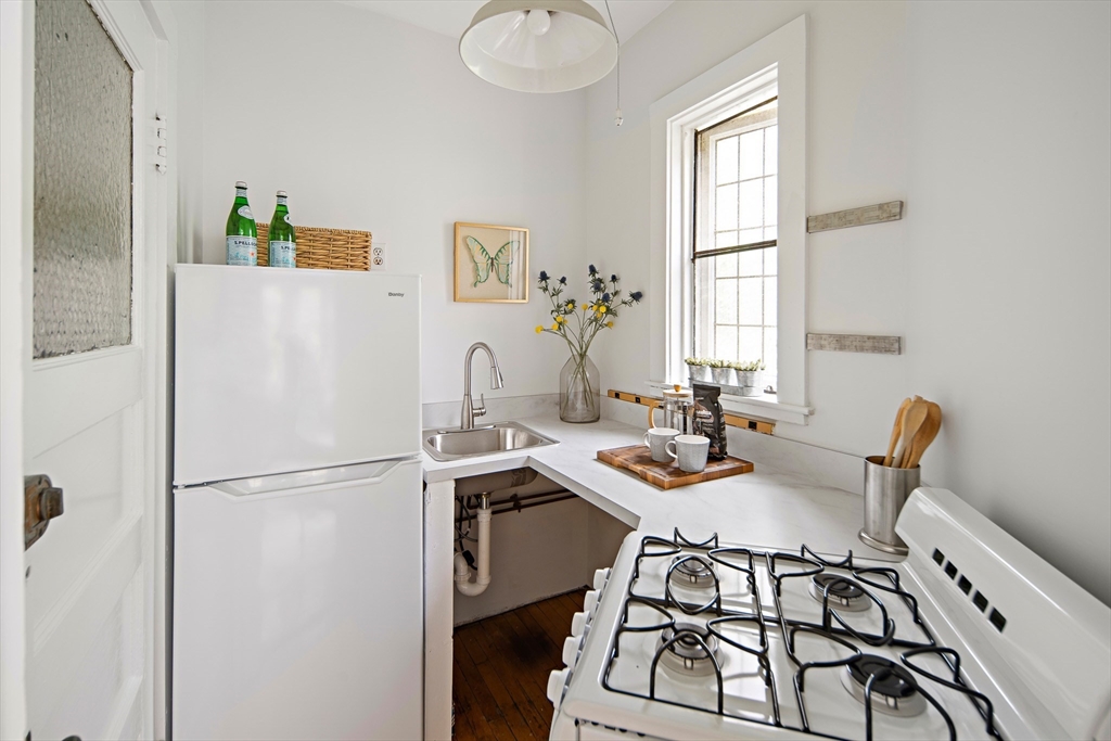 10 Dana Street, Unit 202 Cambridge, MA 02138 - Photo 7 of 16 a kitchen with a refrigerator a stove a sink and a dining table