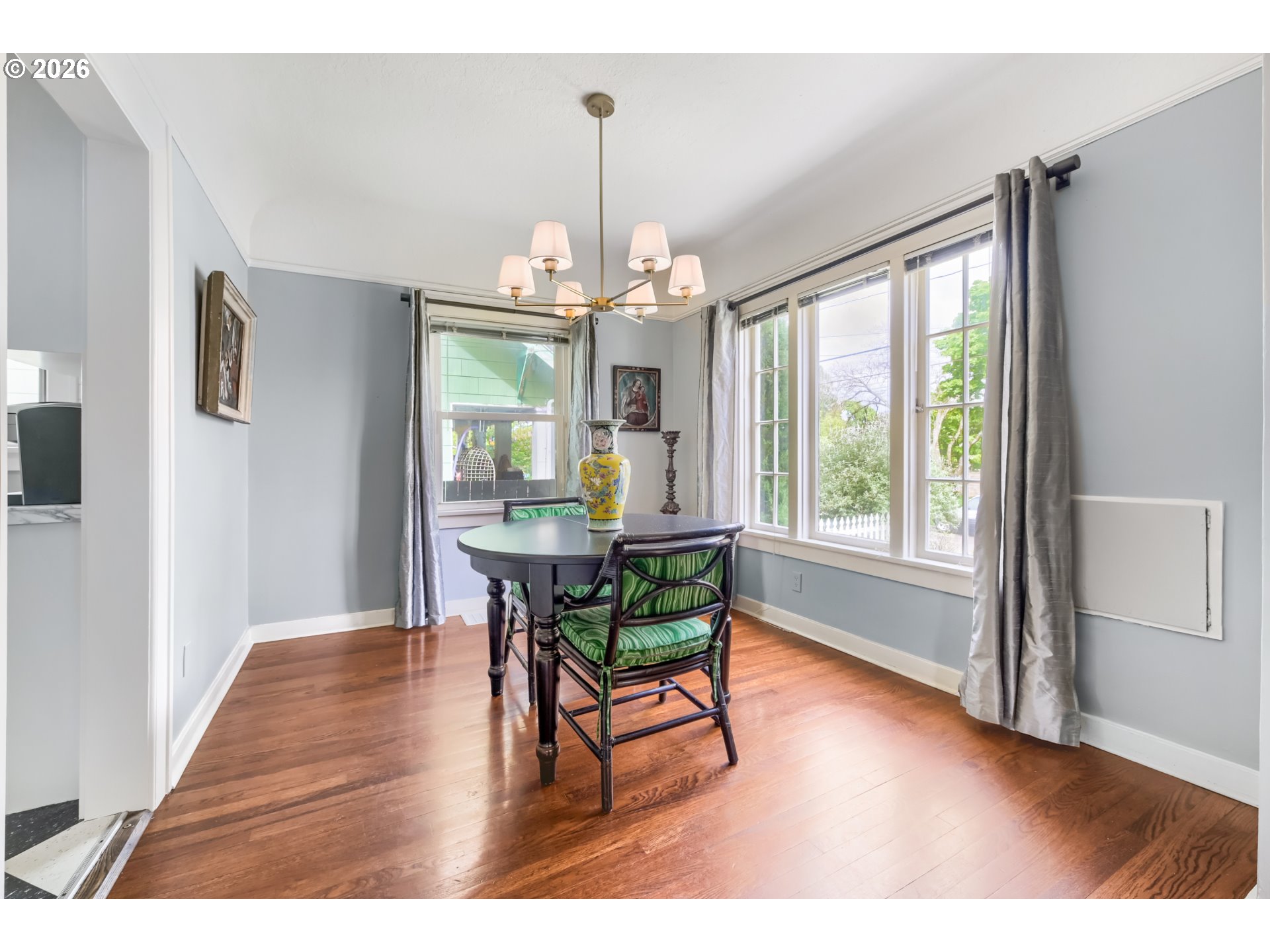 5812 Southeast Bush Street Portland, OR 97206 - Photo 11 of 27 a dining room with wooden floor a chandelier a wooden table and chairs