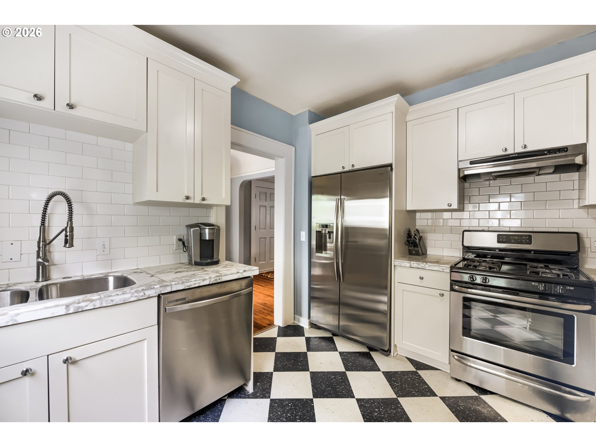 5812 Southeast Bush Street Portland, OR 97206 - Photo 16 of 27 a kitchen with a stove a refrigerator and a sink
