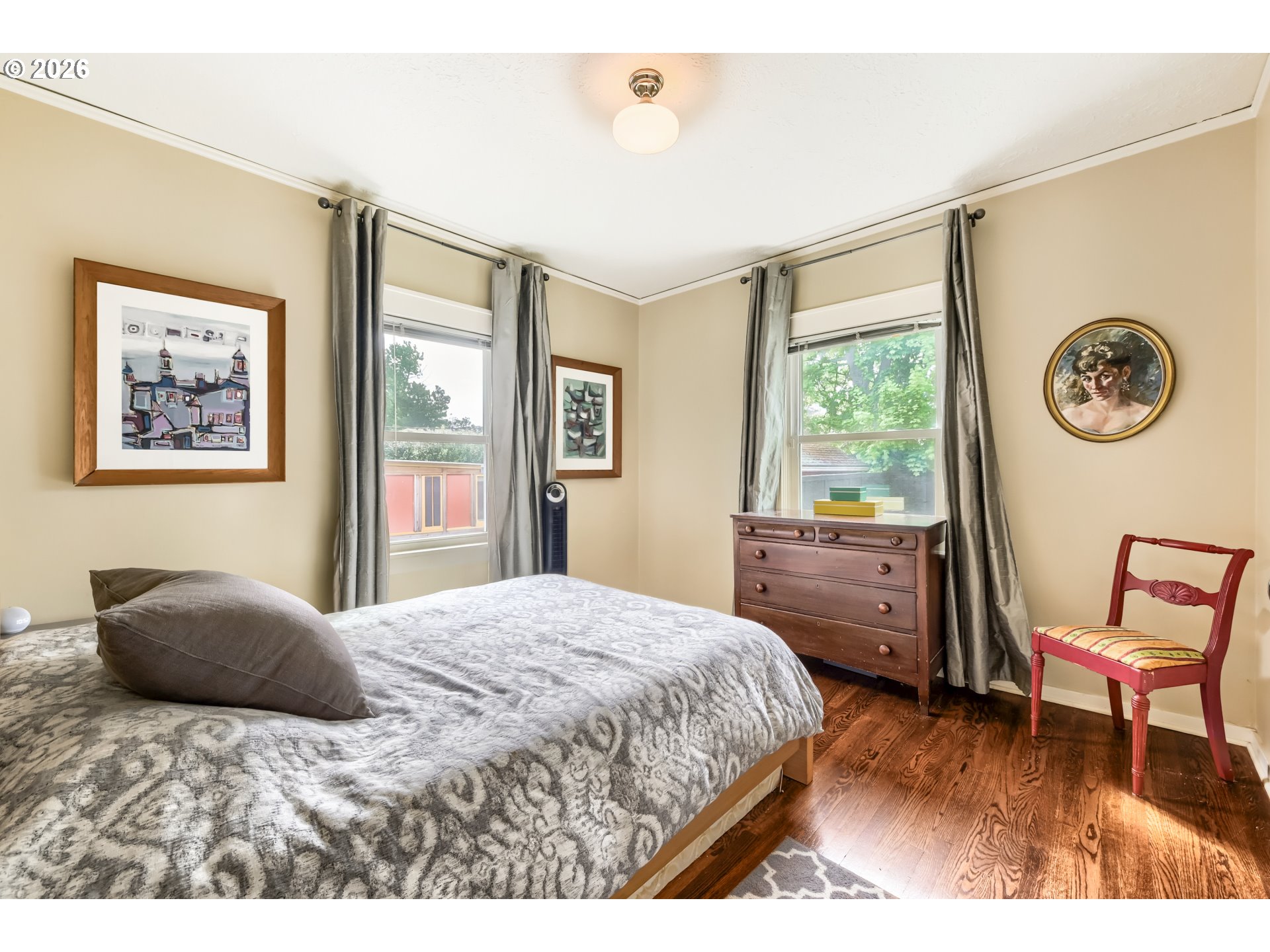 5812 Southeast Bush Street Portland, OR 97206 - Photo 20 of 27 a bedroom with a bed and a table in it with wooden floor