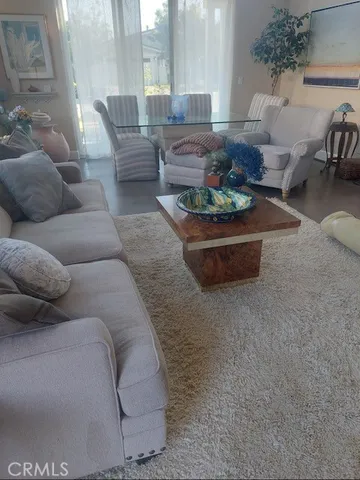 a living room with furniture a chandelier and a dining table