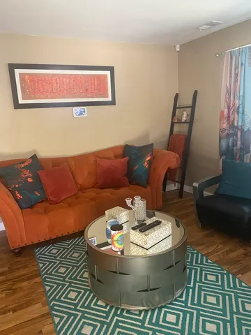 a living room with furniture and wooden floor