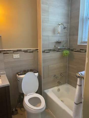 a white toilet sitting next to a bath tub
