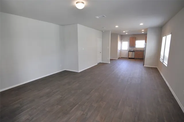 a view of empty room with wooden floor and window