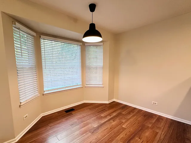 an empty room with wooden floor and entrance