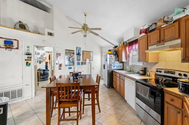 a kitchen with stainless steel appliances a table and chairs in it