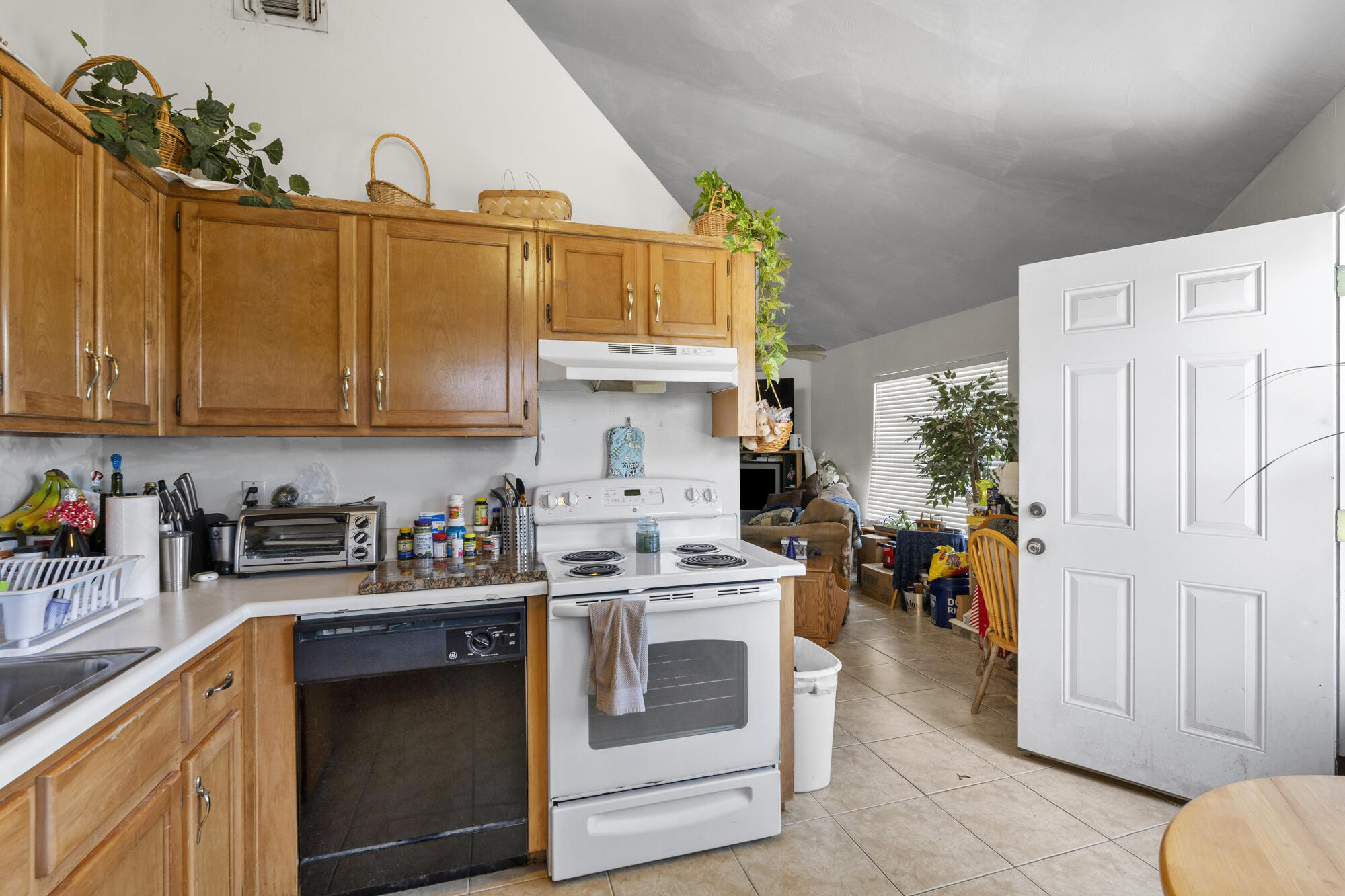 6904 Sea Turtle Circle Navarre, FL 32566 - Photo 40 of 49 a kitchen with stainless steel appliances granite countertop a refrigerator a stove and a sink with wooden cabinets