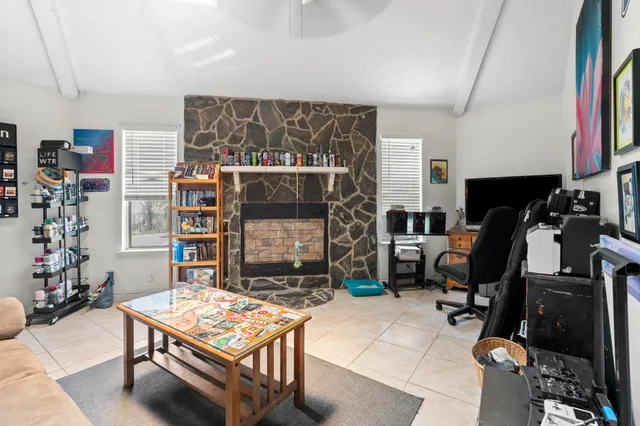 a living room with furniture a flat screen tv and gym equipment