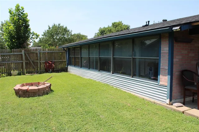 a backyard of a house with yard table and chairs