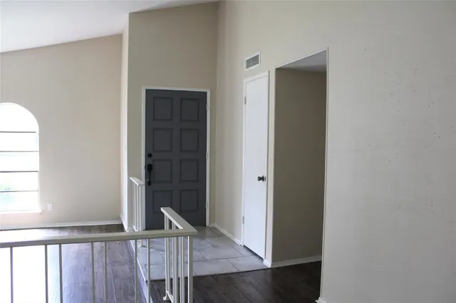 a view of a hallway with wooden floor and entryway