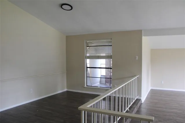 a view of a hallway with wooden floor and entryway