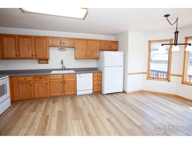 a view of kitchen with wooden floor and electronic appliances