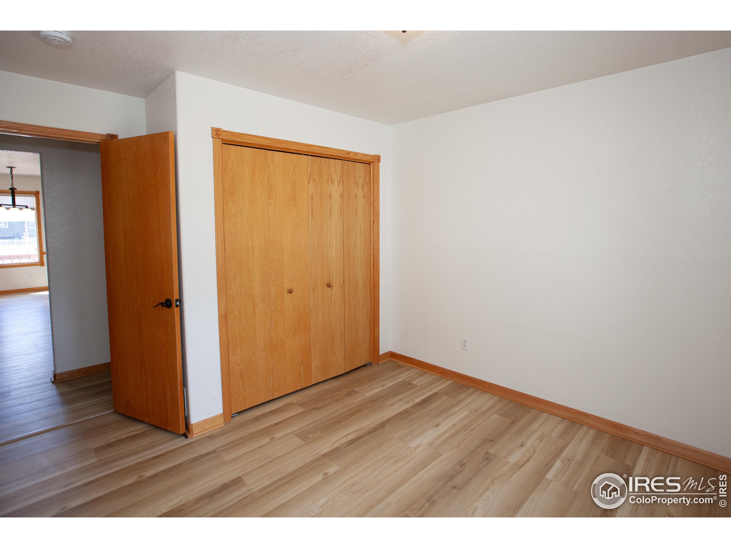 1815 Robin Road Sterling, CO 80751 - Photo 25 of 45 a view of an empty room with wooden floor