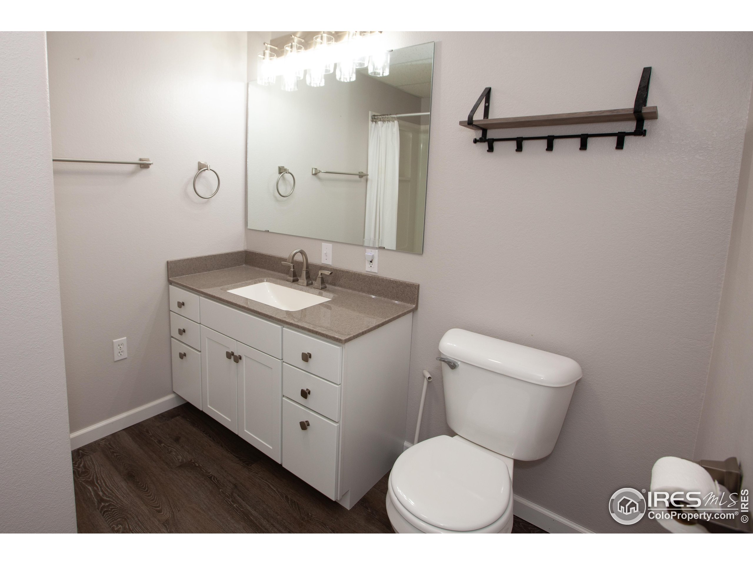 1815 Robin Road Sterling, CO 80751 - Photo 32 of 45 a bathroom with a granite countertop toilet sink and mirror